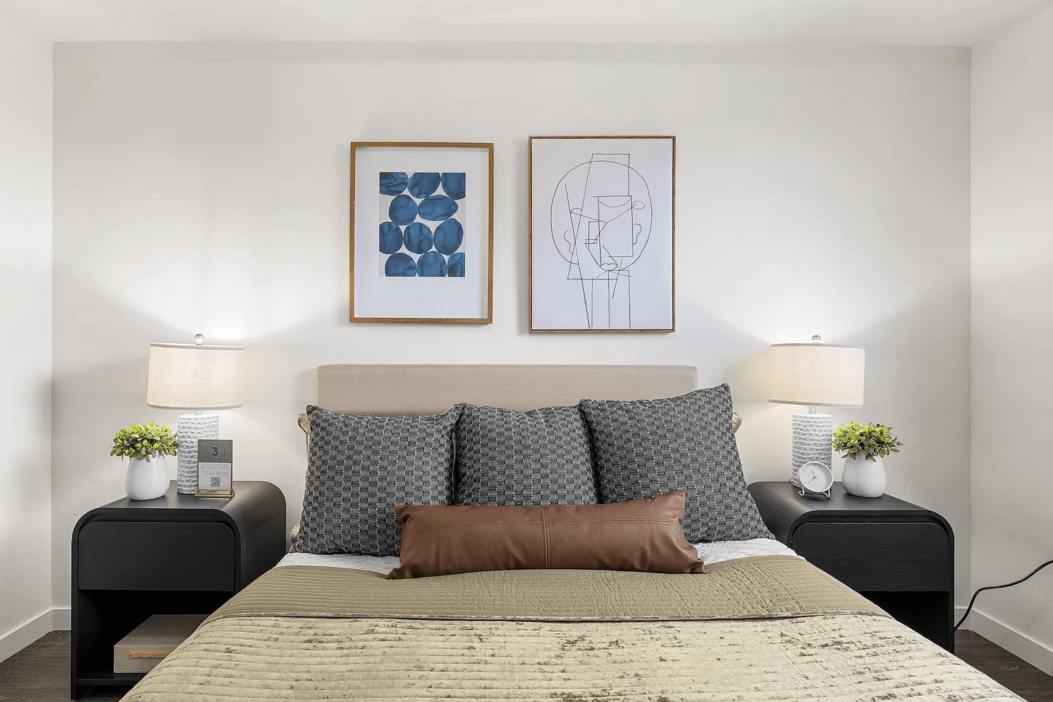 A bedroom with a large bed and two nightstands with lamps.
